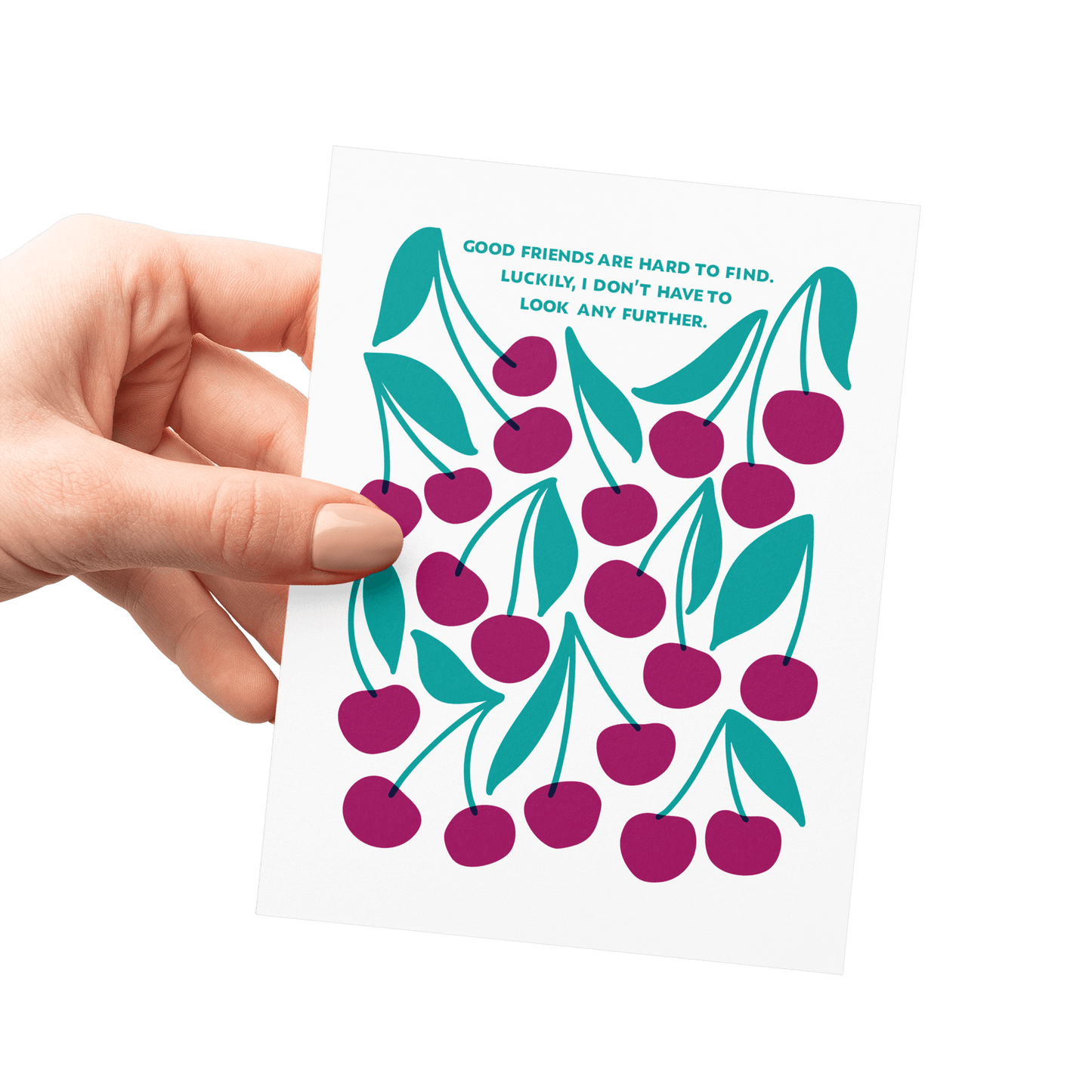 Hand holding a friendship card with ‘Good friends are hard to find. Luckily, I don’t have to look any further.’ in teal hand lettering, surrounded by merlot-colored cherries and green leaves.