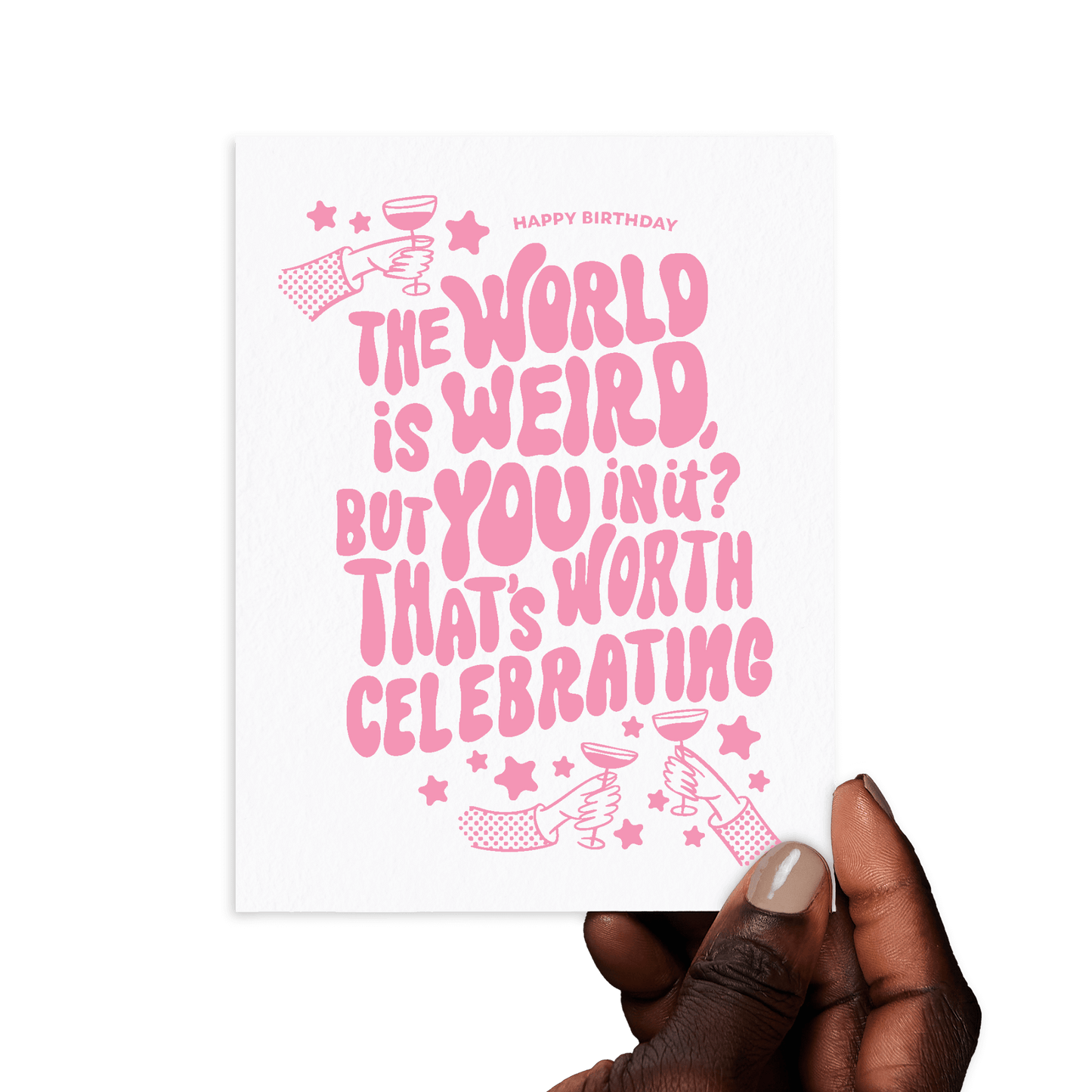 Hand holding birthday card with 'The world is weird, but you in it? That’s worth celebrating' in pink lettering.