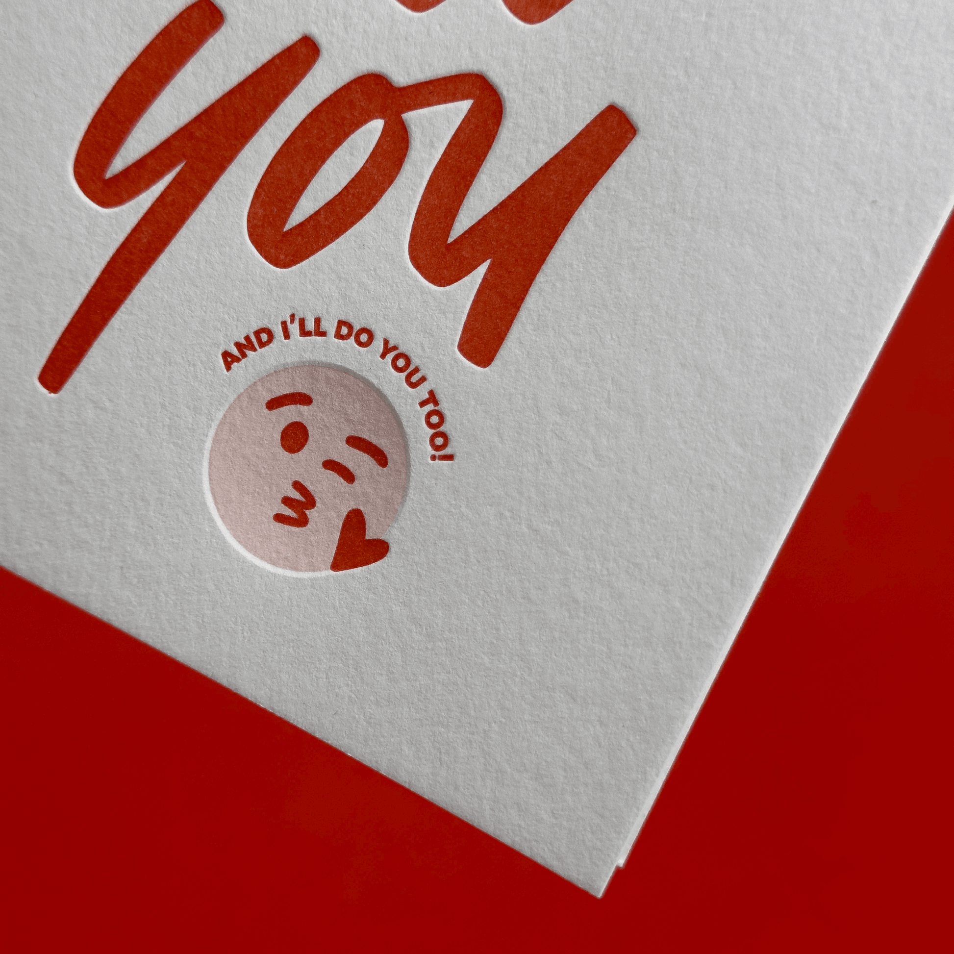 Closeup of card with red hand lettering and a small illustration on a white background