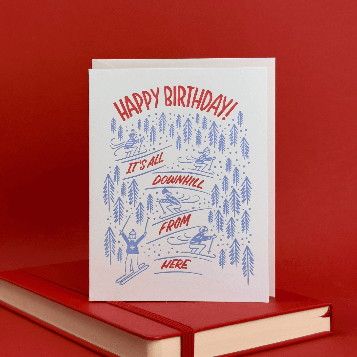 Birthday card with skiing illustration and 'Happy Birthday!' hand lettered on a red background