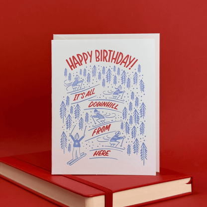 Birthday card with skiing illustration and 'Happy Birthday!' hand lettered on a red background