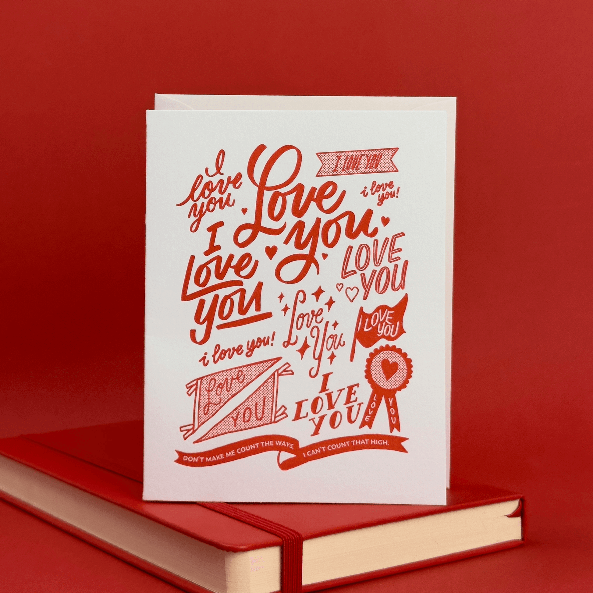 Greeting card with lots of 'I love you' hand lettering and illustrations on a red background.