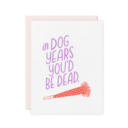 Funny birthday card with 'In dog years, you’d be dead' in lavender hand lettering, featuring a red party horn illustration.