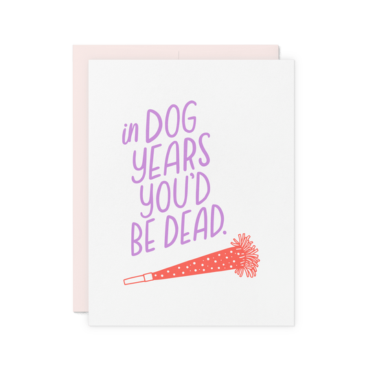 Funny birthday card with 'In dog years, you’d be dead' in lavender hand lettering, featuring a red party horn illustration.