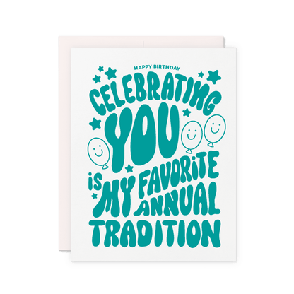Birthday card that reads 'Celebrating you is my favorite annual tradition' in green hand lettering with balloons, stars, and smiley faces.