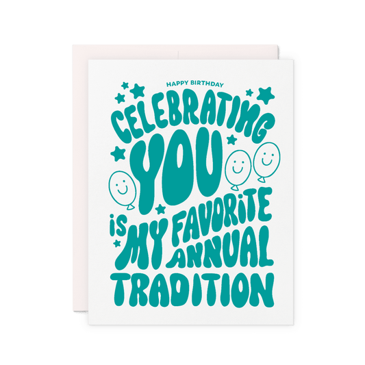 Birthday card that reads 'Celebrating you is my favorite annual tradition' in green hand lettering with balloons, stars, and smiley faces.