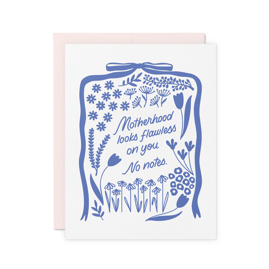 Floral card with ‘Motherhood looks flawless on you. No notes.’ in blue hand lettering, surrounded by vintage-inspired folk illustrations, printed on thick cotton paper.