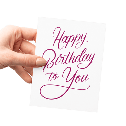 Hand holding an elegant 'Happy Birthday to You' card with magenta script, letterpress printed on cotton paper.