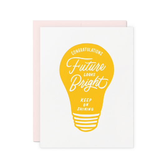 Congratulations card with a bold yellow lightbulb illustration and hand-lettered typography, letterpress printed on cotton paper.