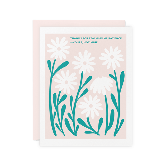 Floral appreciation card with ‘Thanks for teaching me patience—yours, not mine.’ in teal hand lettering, surrounded by white daisies on a pink background, printed on thick cotton paper.