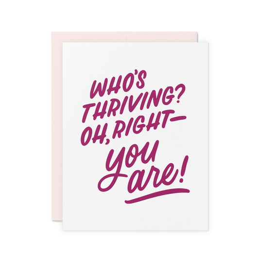 Congratulations card with ‘Who’s thriving? Oh, right—you are!’ in bold burgundy hand lettering, printed on thick cotton paper.