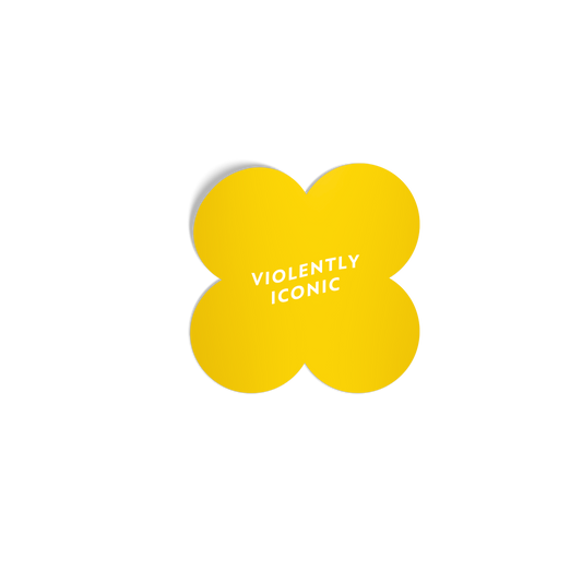Bold yellow quatrefoil sticker with ‘Violently Iconic’ in white lettering, featuring a silky matte mirror finish.