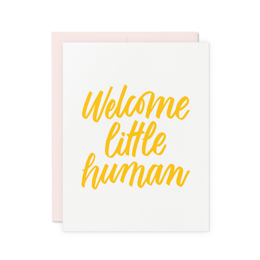 New baby card with 'Welcome Little Human' in yellow hand lettering, letterpress printed on thick cotton paper.