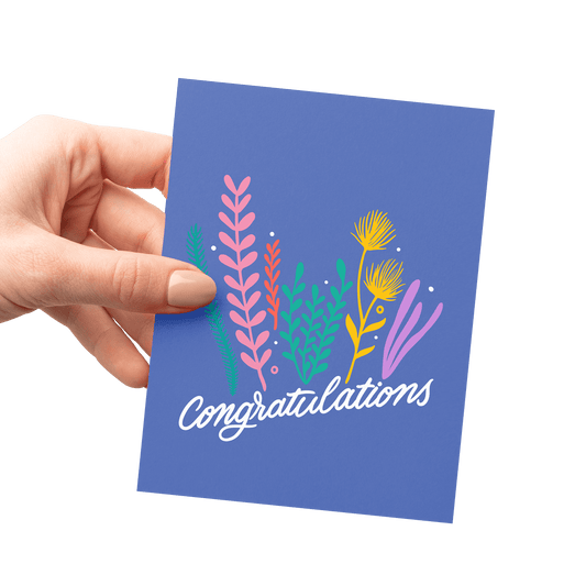 Hand holding a congratulations card with a wildflower bouquet illustration, digitally offset printed on thick cotton paper.