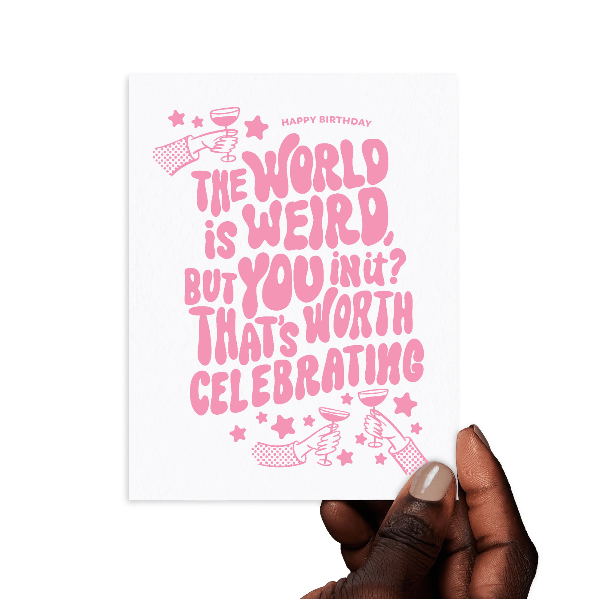 Hand holding birthday card with 'The world is weird, but you in it? That’s worth celebrating' in pink lettering.